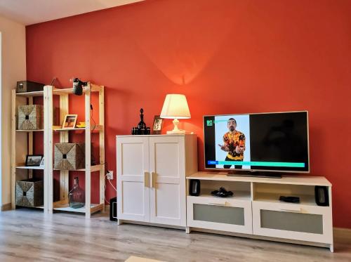 a living room with a television on a white cabinet at Cosy 2 rooms apartment with a view near the forest in Predeal