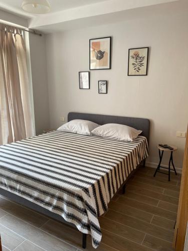 Un dormitorio con una cama con una manta a rayas. en Sunny hill Apartment, en Golem