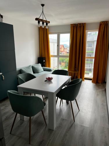 een woonkamer met een witte tafel en stoelen bij Boutique apartments 1 in Sînpetru