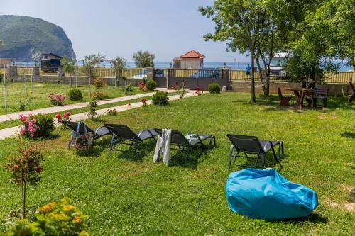 a group of chairs and tables in the grass at Holiday Home Sea in Petrovac na Moru