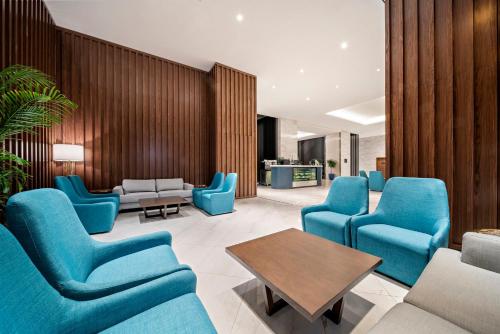 a waiting room with blue chairs and a table at voco Makkah an IHG Hotel in Makkah