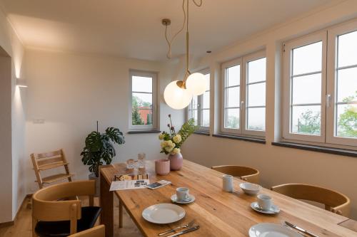 a dining room with a wooden table and chairs at SCHILCHERLANDLEBEN - Langegg in Greisdorf