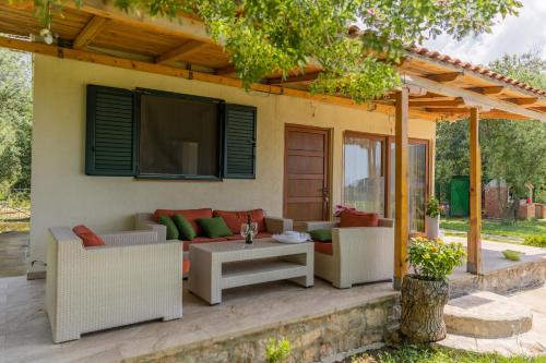 a patio with couches and a tv on a house at Holiday Home Sea in Petrovac na Moru
