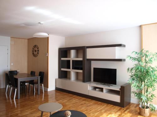 a living room with a television and a table at Apartamento Sadar in Pamplona