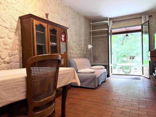 Cette chambre comprend une table, un lit et une fenêtre. dans l'établissement 2 pièces jardin au pied des pistes, à Valdeblore