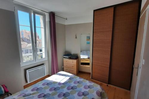una camera da letto con un letto e una grande finestra di Appartement T2, 1 seule chambre, très lumineux a Bandol