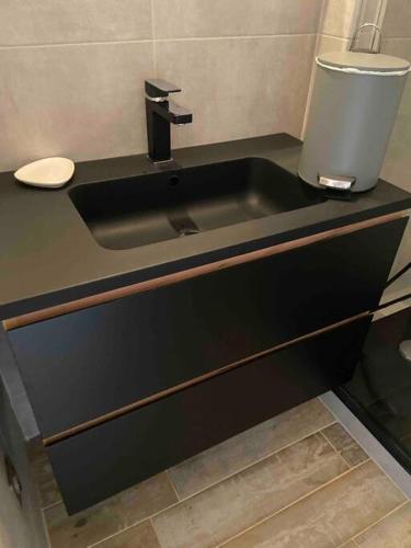une salle de bain avec un lavabo noir et des toilettes dans l'établissement Appartement T2, 1 seule chambre, très lumineux, à Bandol