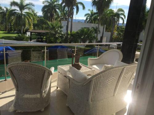 een balkon met rieten stoelen en uitzicht op een zwembad bij Casa Campestre en Melgar in Melgar