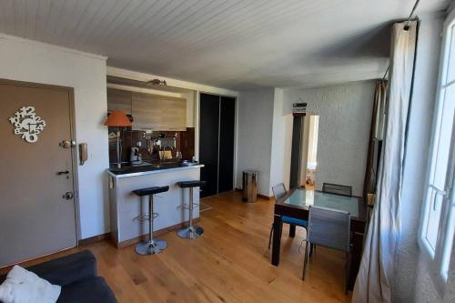 un soggiorno con un tavolo e una cucina di Appartement T2, 1 seule chambre, très lumineux a Bandol