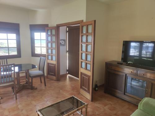 a living room with a table and a tv at Casa Velay in Fisterra