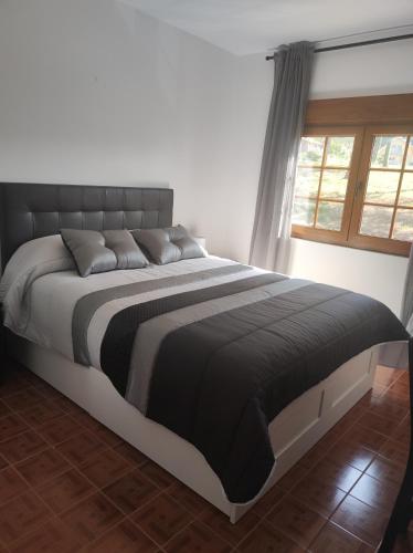 a large bed in a bedroom with a window at Casa Velay in Fisterra