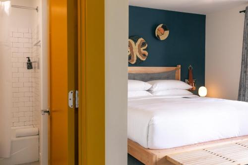 a bedroom with a white bed and a blue wall at Bode Nashville in Nashville