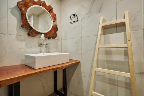 a bathroom with a white sink and a ladder at Iniohos Zante Hotel & Suites in Argasi