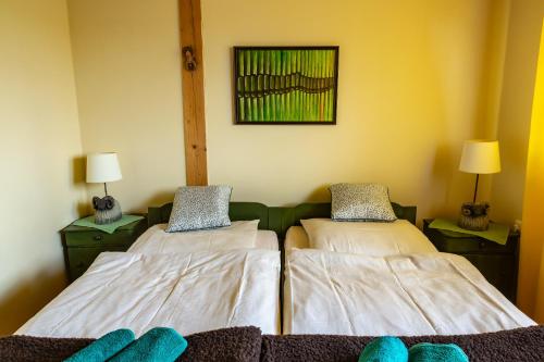 two twin beds in a room with two lamps at Kowalowe Skały SPA&MORE in Jelenia Góra