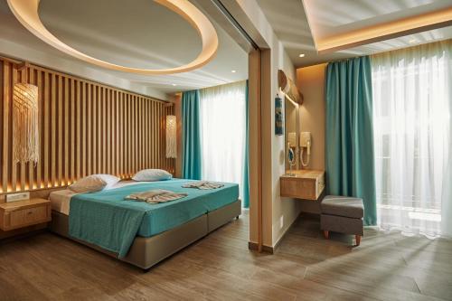 a bedroom with a bed and a large window at Iniohos Zante Hotel & Suites in Argasi