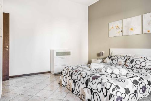 ein weißes Schlafzimmer mit einem schwarzen und weißen Bett in der Unterkunft Casa Vacanza via Sottocorno in Busto Arsizio