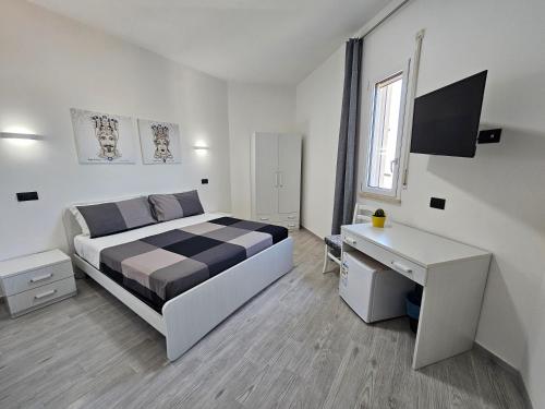 - une chambre blanche avec un lit et un bureau dans l'établissement FronteMare Locazione Turistica, à Porto Empedocle