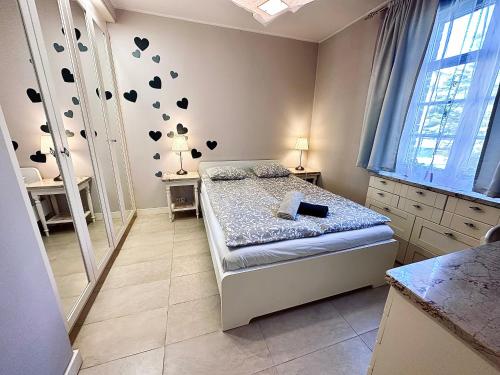 1 dormitorio con 1 cama con corazones en la pared en Apartament Sopot - Kazimierza, en Sopot
