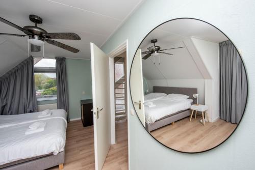 una camera da letto con specchio, letto e scala di Vakantiehuis Bongel 1, Ter Herne a Terherne