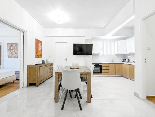 een keuken en eetkamer met een tafel en stoelen bij Victroria Grand Palace Apartment in Athene