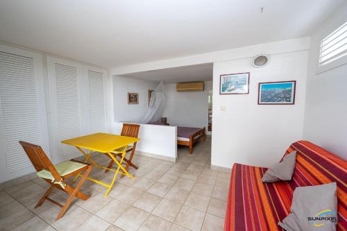 a living room with a yellow table and chairs at Villa La Lady 8, 300 m de la plage, vue mer à 180° in Les Anses-dʼArlets