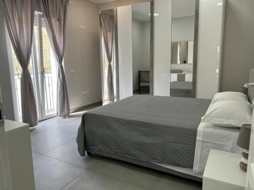 - une chambre avec un lit et une grande fenêtre dans l'établissement Villa Donnarumma, à Castellammare di Stabia