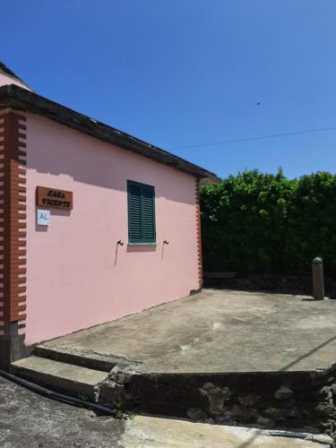a pink building with a window on the side of it at Casa vicente in Santa Cruz das Flores