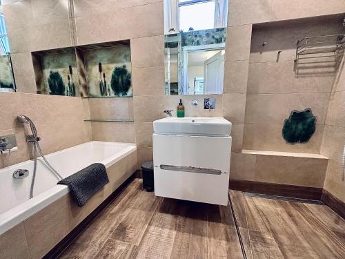 a bathroom with a tub and a sink and a bath tub at Apartament Sopot - Kazimierza in Sopot