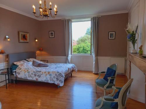 1 dormitorio con 1 cama, ventana y sillas en Au pays de Jacquou : Chambre d’hôtes et table d’hôtes, en Fossemagne