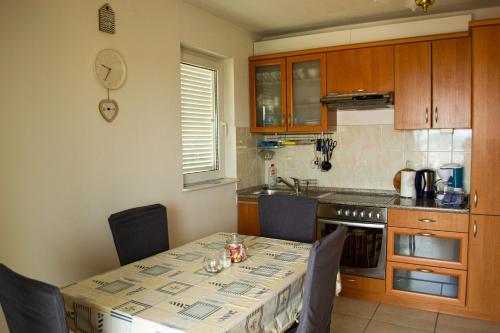 a kitchen with a table and chairs and a kitchen with a counter at Apartment SeaShell in Jadranovo