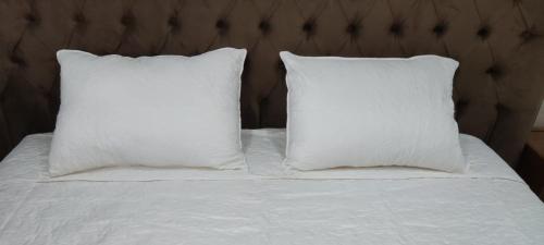 twee kussens bovenop een wit bed bij Nador New in Nador
