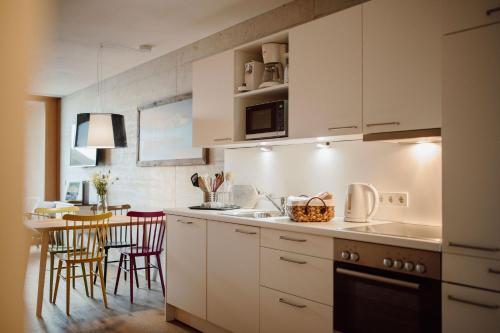 a kitchen with white cabinets and a table with chairs at Appartement Schwarz in Sankt Johann im Pongau