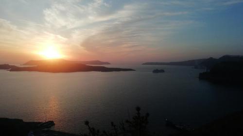 a sunset over a large body of water at Poudras Amazing View Caldera in Órmos Athiniós