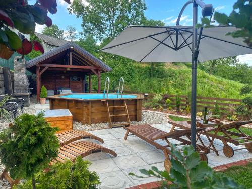 een patio met een zwembad, een tafel en stoelen en een parasol bij Kuća za odmor Zora 