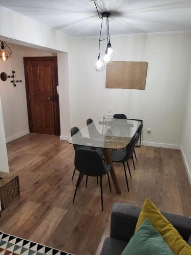 a dining room with a glass table and chairs at Cantinho de Benfica in Amadora