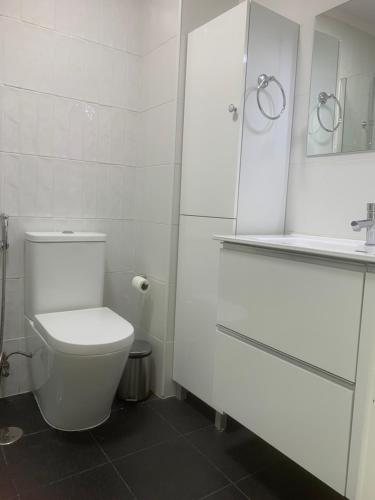 bagno bianco con servizi igienici e specchio di Cantinho de Benfica ad Amadora