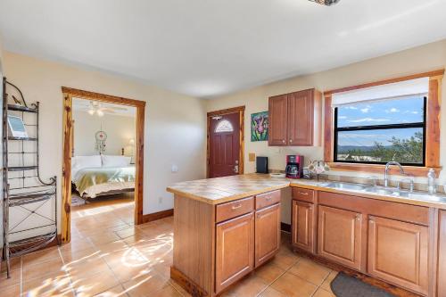a kitchen with a sink and a window and a bed at Peggy's View - Uplifting Cozy Mountain Views in Alpine