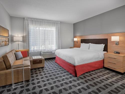Habitación de hotel con cama grande y sofá en TownePlace Suites by Marriott Edmonton Sherwood Park, en Sherwood Park