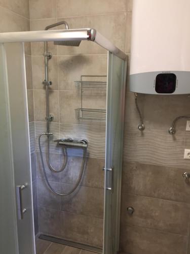 a shower in a bathroom with a glass door at House Carlo Ponty in Tass