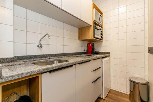 Una pequeña cocina con fregadero y microondas. en WI-FI 500MB | Piscina | Sacada com Vista Mar #CA46, en Florianópolis