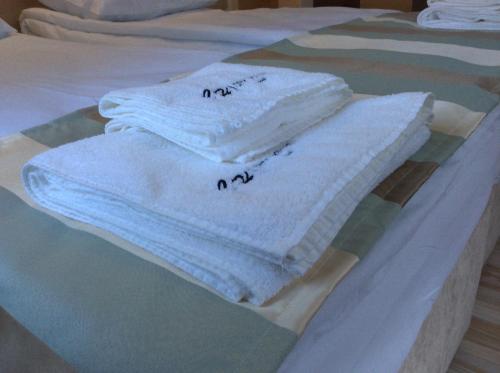 - un ensemble de serviettes assises au-dessus d'un lit dans l'établissement City House Family Hotel & Restaurant, à Ruse