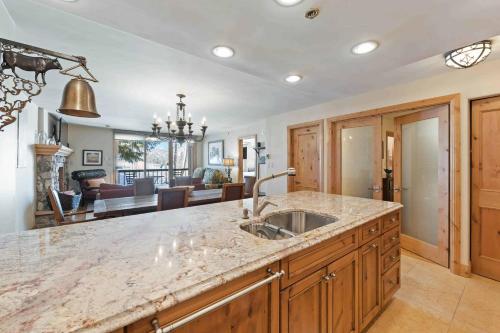 a kitchen with a sink and a living room at Borders Lodge by East West Hospitality in Beaver Creek