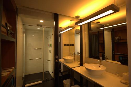a bathroom with two sinks and a walk in shower at Aloft Bengaluru Whitefield in Bangalore