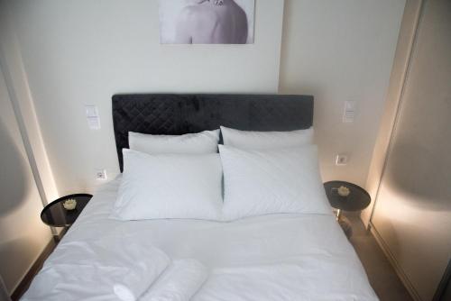 a bed with white sheets and pillows in a bedroom at Poly s home in Ioannina