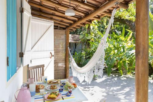 - une table avec de la nourriture et un hamac sur la terrasse dans l'établissement Pousada Villa Serena, à Caraíva
