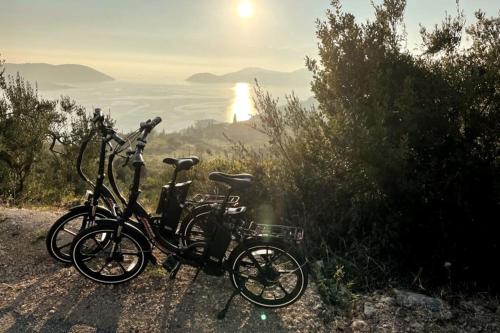 two bikes parked on a hill with the sun in the background at Villa Ansay with heated Swim Spa pool and sea view in Zaton