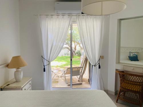a bedroom with a bed and a sliding glass door at Casa da Balaia in Albufeira