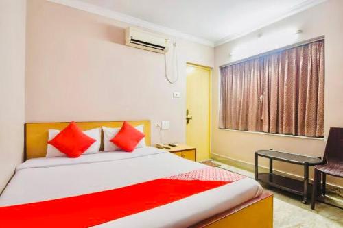 a bedroom with a bed with red pillows and a window at Hotel Falcon House ! Puri - ViDi Group in Puri