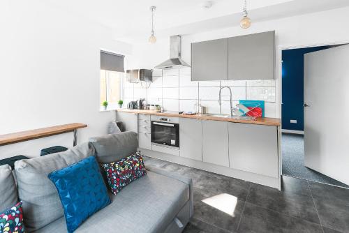 a living room with a couch and a kitchen at MyCityHaven - The Bathford Annexe in Bath