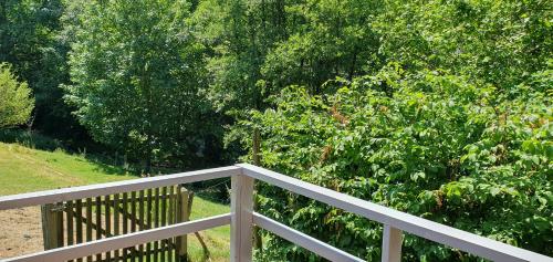 a white wooden fence next to a bush at Chalet Les Allores Dohan (Bouillon) in Bouillon